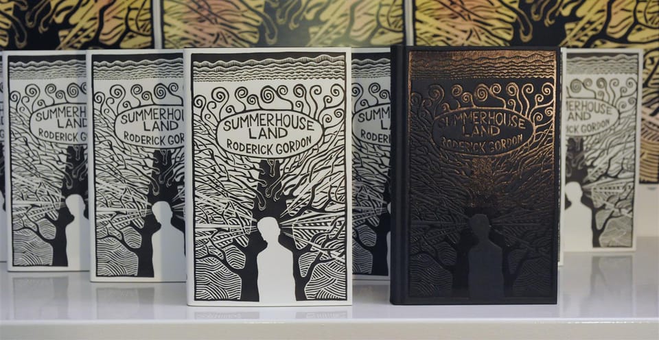 A row of Summerhouse Land hardbacks in their printed jackets, with one black cloth-bound copy blocked in the same design.