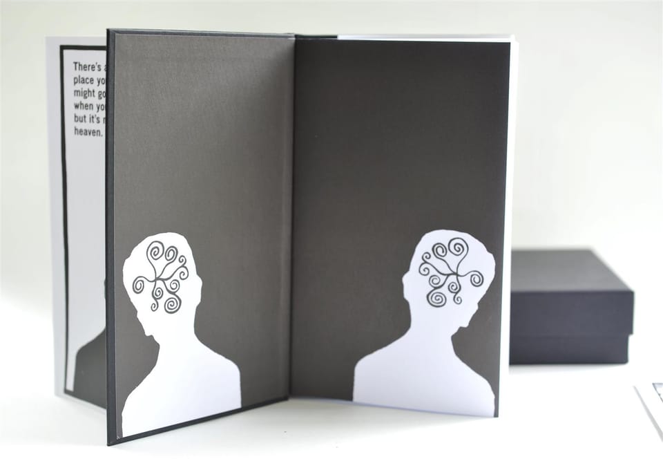 The book opened flat to its printed endpapers, the black box resting to one side.