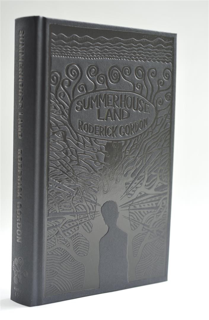 The black cloth-bound book standing upright, the blocked tree illustration visible on the cover.