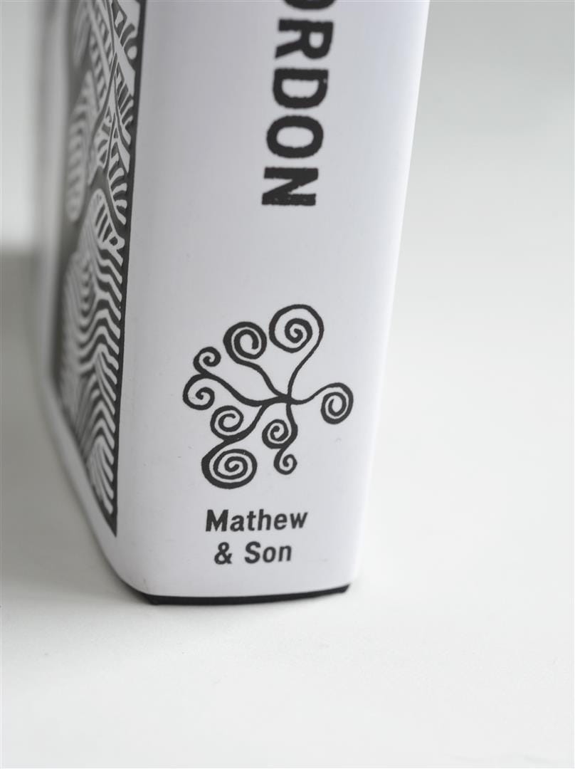 Detail of the book spine showing the author name and the publisher’s spiral device.