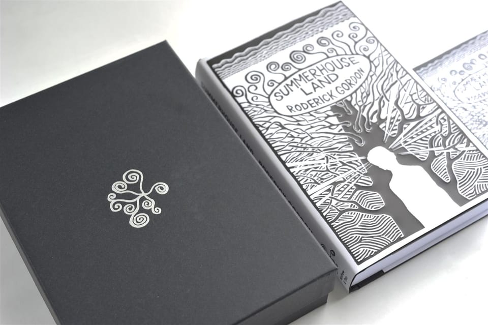 The boxed edition opened at an angle, the jacketed book seated within.