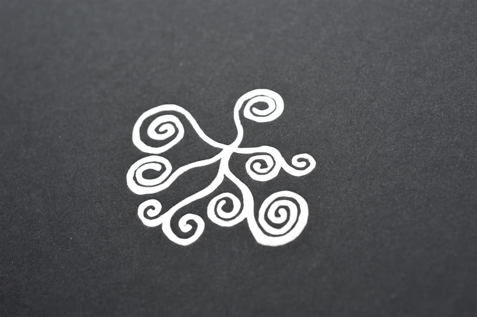 Close-up of the spiral motif embossed in silver foil on the black box lid.